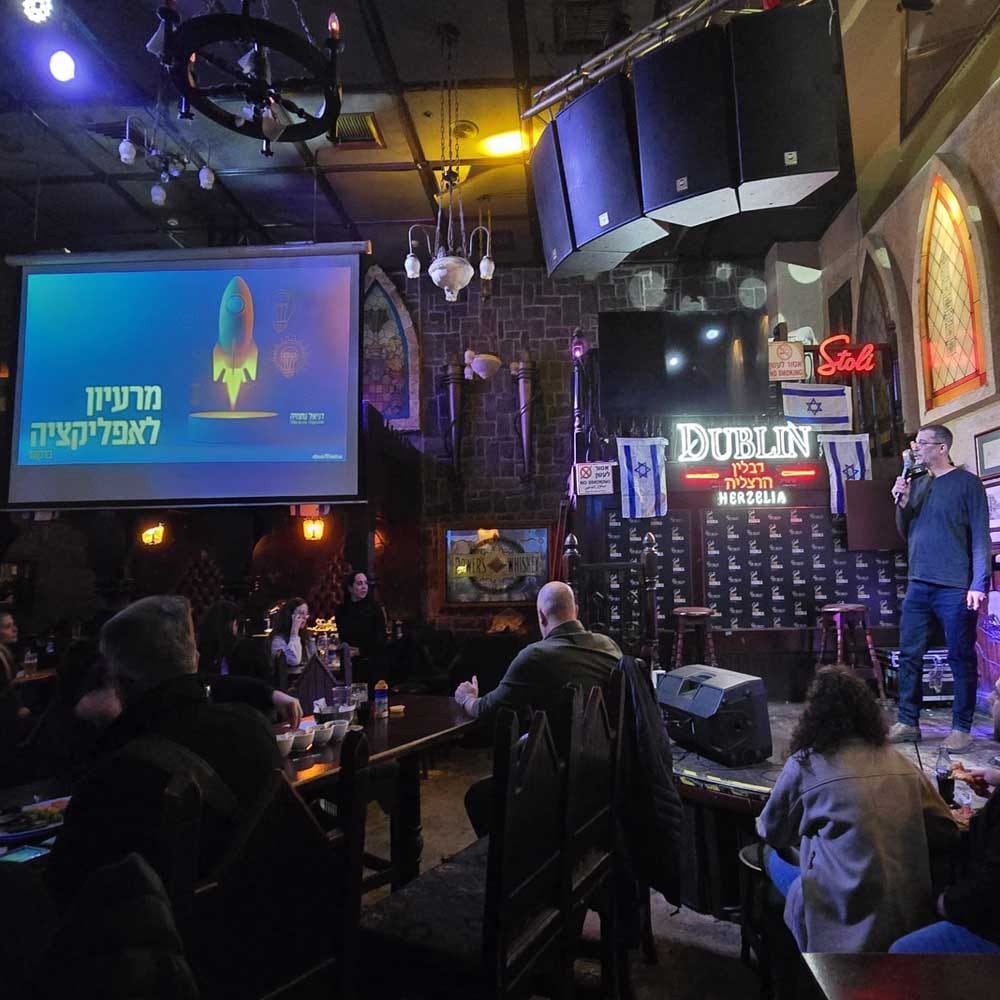 דניאל נחמיה על במה מול קהל — הרצאת בינה מלאכותית